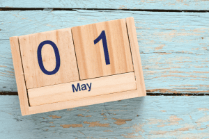 Wooden calendar displaying May 1 date.